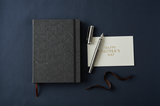 Premium hardcover journal and pen presented as a gift on dark navy linen — Father's Day gift guide by Journal Venue