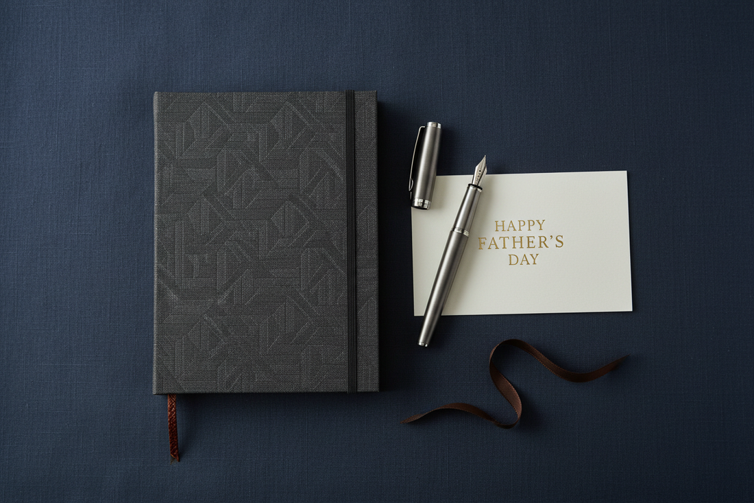 Premium hardcover journal and pen presented as a gift on dark navy linen — Father's Day gift guide by Journal Venue